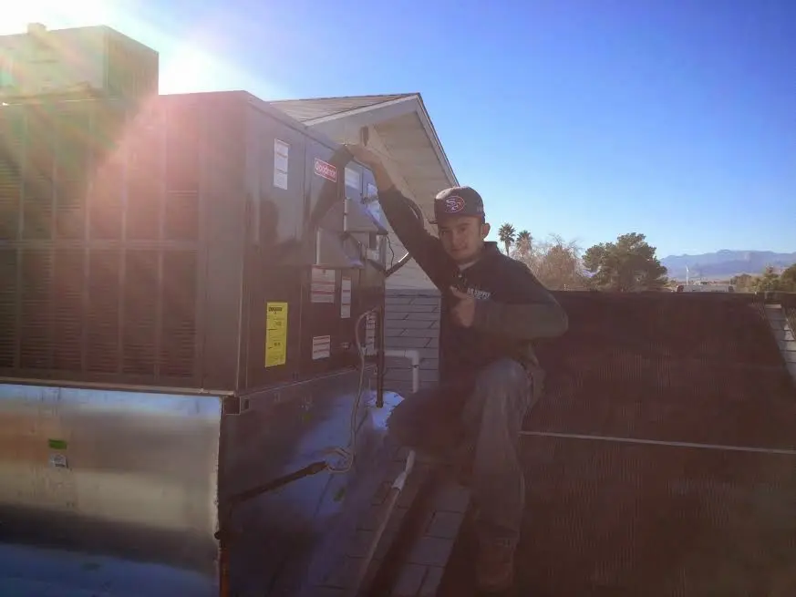 HVAC technician performing HVAC Inspection on a rooftop unit in Littleton